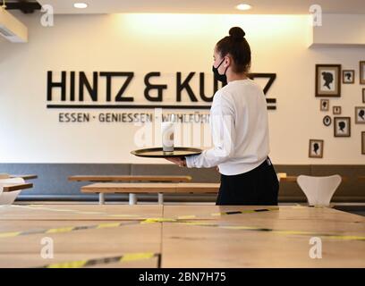 Mainz, Deutschland. Mai 2020. Kellnerin Tabatha Enderle geht mit einer Gesichtsmaske durch das Mainzer Restaurant 'Hintz & Kuntz'. Seit dem 13. Mai 2020 dürfen Restaurants und Kneipen in Rheinland-Pfalz unter strengen Auflagen wieder eröffnet werden. Kredit: Arne Dedert/dpa/Alamy Live News Stockfoto