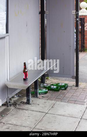 Leere Bierflaschen wurden in einem Busshutze in Farnworth, in der Nähe von Bolton Greater Manchester, abgestellt. Stockfoto
