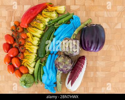 Regenbogen der Gemüse Hoffnung Symbol Covid-19 Coronavirus Pandemie: Tomaten, Zucchini Blumen, Erbsen, Artischocken, Endive, Aubergine, chirurgische Handschuhe Stockfoto