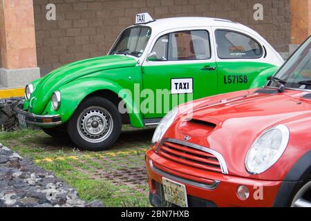 Mexikanisches grünes Taxi auf einem Parkplatz und ein rotes Auto in Mexiko-Stadt Stockfoto