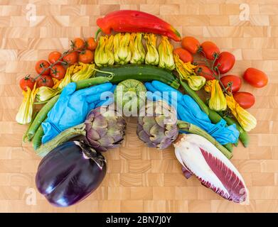 Regenbogen der Gemüse Hoffnung Symbol Covid-19 Coronavirus Pandemie: Tomaten, Zucchini Blumen, Erbsen, Artischocken, Endive, Aubergine, chirurgische Handschuhe Stockfoto