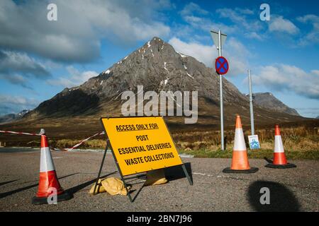 Geschlossene Verkehrsschilder in Glencoe aufgrund der Sperrung der Corona-Virus-Pandemie. Straße, die nach Glen Etive mit Buachaille Etive Mor führt, im Hintergrund. Stockfoto