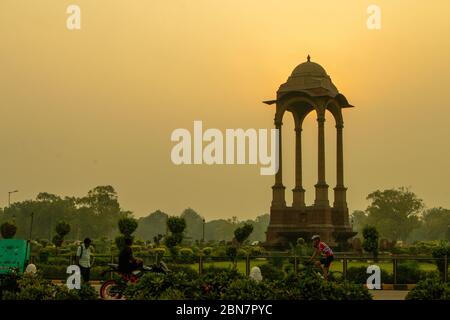 India Gate, Neu Delhi: Amar Jawan Jyoti. Die Sonne geht hinter der Silhouette von Amar Jawan Jyoti am India Gate auf Stockfoto