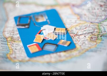 Nahaufnahme von sim-Karten auf einer Karte; Reisende können SIM-Karten nach Land eintauschen, um in der Kommunikation zu bleiben und gleichzeitig die Kosten niedrig zu halten. Stockfoto
