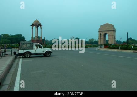 Polizeiwagen vor einem leeren India Gate war Memorial in Delhi während der Sperrung geparkt. Stockfoto