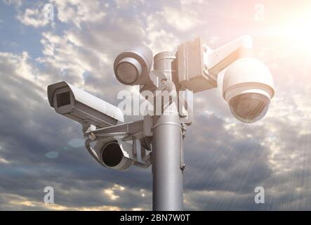 CCTV-Kameras auf einem Mast vor einem blauen bewölkten Himmel. Stockfoto