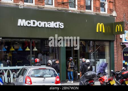 London, Großbritannien. 13 Mai 2020. Lieferfahrer warten auf Bestellungen, da das McDonald's Fast-Food-Restaurant in Harrow während der laufenden Coronavirus-Pandemie für „McDelivery“ wieder eröffnet wird. Das Restaurant ist eines von 14 in Großbritannien, das die Kette teilweise wieder eröffnet, mit einer begrenzten Speisekarte und Lieferung nur. Die Lieferung erfolgt durch Dritte wie Uber Eats und Deliveroo. Kredit: Stephen Chung / Alamy Live News Stockfoto