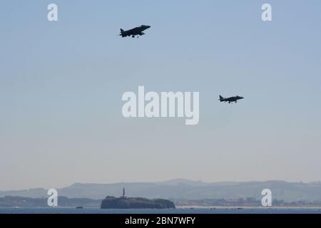 Serie 105 von 165 zwei McDonnell Douglas AV-8B Harrier II's Schwebt mit der Insel des Moors (Isla del Mouro) Am Tag der Streitkräfte Spanien Stockfoto