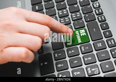 Hand in Handschuhe warten auf die Taste wieder öffnen auf der Tastatur, Konzept für die Wiedereröffnung Geschäft nach Covid-19 Coronavirus Nahaufnahme zu drücken Stockfoto