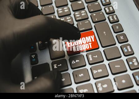 Hand in Handschuhe warten auf die Taste wieder öffnen auf der Tastatur, Konzept für die Wiedereröffnung Geschäft nach Covid-19 Coronavirus Nahaufnahme zu drücken Stockfoto