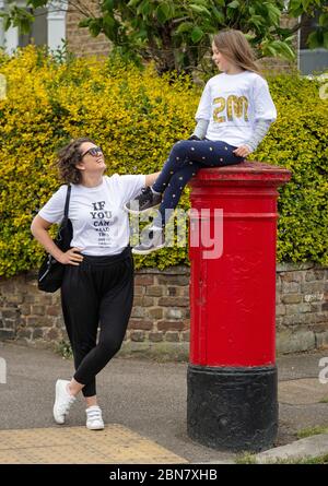 Fiona und ihre Tochter Lola aus London tragen T-Shirts mit dem Slogan: „Wenn Sie dies lesen können, sind Sie zu nahe an COVID“, die vom globalen Unternehmen für die Markenumwandlung FutureBrand als gemeinnützige Initiative ins Leben gerufen wurden, um die wichtigsten Richtlinien für soziale Distanzierung zu stärken, während die Nation aus der Sperrung der Coronavirus-Pandemie herauskommt. Stockfoto