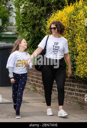 Fiona und ihre Tochter Lola aus London tragen T-Shirts mit dem Slogan: „Wenn Sie dies lesen können, sind Sie zu nahe für COVID“, die vom globalen Unternehmen zur Markenumwandlung FutureBrand als gemeinnützige Initiative ins Leben gerufen wurden, um wichtige Richtlinien zur sozialen Distanzierung zu verstärken, während die Nation aus der Blockierung der Coronavirus-Pandemie herauskommt. Stockfoto