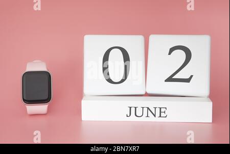 Moderne Uhr mit Würfelkalender und Datum 02. juni auf rosa Hintergrund. Konzept Sommer Zeit Urlaub. Stockfoto