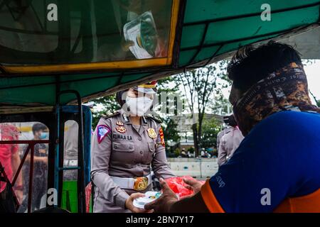 Makassar, Indonesien. Mai 2020. Die Verkehrspolizei Süd Sulawesi verteilt Lebensmittel, um schnell zu brechen, und maskiert Fußgänger und Autofahrer auf den Straßen. (Foto: Herwin Bahar/Pacific Press) Quelle: Pacific Press Agency/Alamy Live News Stockfoto