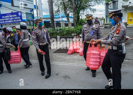 Makassar, Indonesien. Mai 2020. Die Verkehrspolizei Süd Sulawesi verteilt Lebensmittel, um schnell zu brechen, und maskiert Fußgänger und Autofahrer auf den Straßen. (Foto: Herwin Bahar/Pacific Press) Quelle: Pacific Press Agency/Alamy Live News Stockfoto