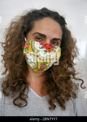 Beirut, Libanon. Mai 2020. Sandra, 30, posiert in einer maßgeschneiderten Maske inmitten der Coronavirus-Pandemie, die mehrere Modedesigner zwang, ihre Geschäfte zu schließen. Trotz der Krise fanden libanesische Designer schnell eine neue Möglichkeit, mit modischen Gesichtsmasken beschäftigt zu bleiben und ihre Kunden mit farbenfrohen und einzigartigen Designs zu locken. Quelle: Marwan Naamani/dpa/Alamy Live News Stockfoto