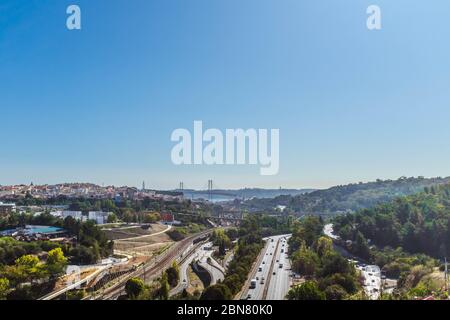 Infrastruktur von Lissabon mit 25 de Abril Brücke und Heiligtum von Christus dem König im Hintergrund von Águas Livres Aquädukt, horizontale Ernte gesehen. Stockfoto