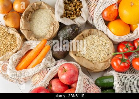 Leisten, Obst, Gemüse, Nüsse in Papier und Baumwollbeutel. Draufsicht. Zero Waste, umweltfreundliches oder plastikfreies Lifestyle-Konzept. Stockfoto