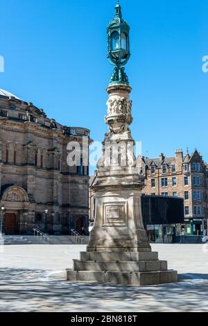 Gedenklampenpfosten (19. Jahrhundert) mit University of Edinburgh McEwan Hall im Hintergrund in Bristo Square, Southside, Edinburgh, Schottland, Großbritannien Stockfoto