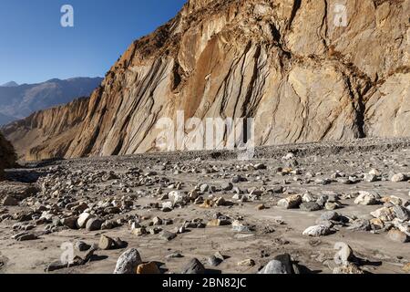 Das trockene Bett eines Gebirgsflusses im Himalaya. Steine im Sand am Flussgrund im Herbst. Nepal Stockfoto