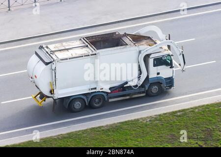 LKW für die Abfallsammlung in Wohngebieten der Stadt fährt auf der Straße Stockfoto