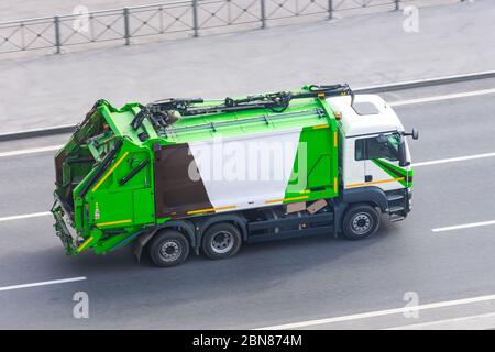 LKW für die Abfallsammlung in Wohngebieten der Stadt fährt auf der Straße Stockfoto