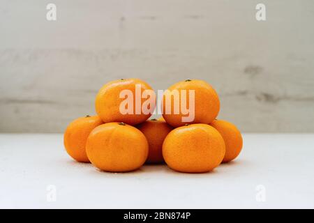 Stapel frischer saftiger Mandarinen auf EINEM Holztisch Stockfoto