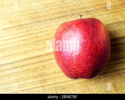Ein einzelner braeburn Apfel auf einem Holzhackbrett mit Kopierraum Stockfoto