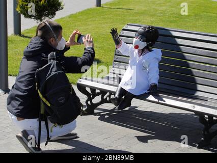 13. Mai 2020, Kiew, Ukraine: Ein Aktivist fotografiert eine Skulptur, die die Gründer von Kiew zeigt, die während einer Kundgebung zur Unterstützung ukrainischer Mediziner und Ärzte während des Covid-19-Coronavirus-Ausbruchs am 13. Mai 2020 in Kiew, Ukraine, in Schutzanzüge gesehen wurden. Die Aktivisten hielten die Kundgebung ab, um den Ärzten und Ärzten, die mit dem Coronavirus COVID-19 kämpfen, Respekt und Dankbarkeit auszudrücken. Die Ukraine begann, die Anti-Virus-Beschränkungen nach Monaten der Quarantäne zu lockern, eingeführt im Land seit dem 12. März 2020 und verlängert später bis zum 22. Mai. (Bild: © Serg Glovny/Z Stockfoto