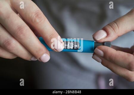 Diabetes-Patient Drehknopf am Ende des Insulin-Pens und wählen Sie die richtige Insulindosis für die Injektion Stockfoto