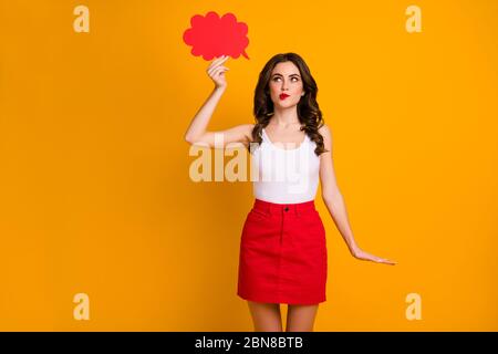 Foto von ziemlich fröhlich Dame halten großen Papier Geist Wolke interessiert suchen leer Raum beißen Lippen listig tragen weiß lässig Tank-Top rot kurzen Rock Stockfoto