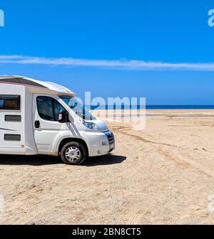 Camper van geparkt an einem Strand in der wunderbaren Oase Piscinas, mit imposanten und gewundenen Dünen von feinem, warmen und goldenen Sand Stockfoto