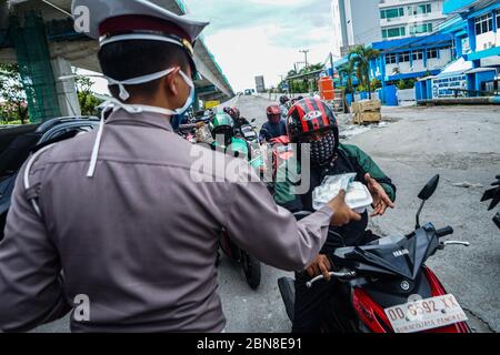 Makassar, Indonesien. Mai 2020. Die Verkehrspolizei Süd Sulawesi verteilt Lebensmittel, um schnell zu brechen, und maskiert Fußgänger und Autofahrer auf den Straßen. (Foto: Herwin Bahar/Pacific Press/Sipa USA) Quelle: SIPA USA/Alamy Live News Stockfoto