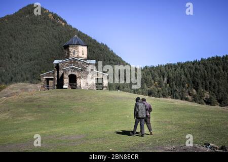 Kaukasus, Georgien, Tusheti Region, Shenako. Zwei Freunde gehen zur Kirche in Shenako. Stockfoto