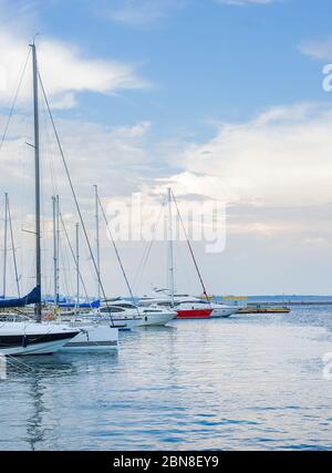 Meereslandschaft mit vielen Luxusbooten und Yachten bei Sonnenuntergang am Pier vertäut. Sommerurlaub unter den Segeln Yacht als Ihre Reisegeschichte. Odessa Stockfoto