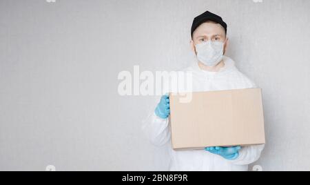 Lieferung Mann hält Kartons in medizinischen Maske und Gummihandschuhe. Online-Shopping unter Quarantäne stellen Stockfoto