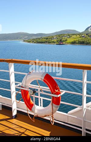 Deck eines Schiffs & Lebensrings, wie es Fjorde, Inseln und Innenpassagen kreuzt; der Andfjorden & Vestfjorden, zwischen Bodo & Hammerfest, Norwegen. Stockfoto