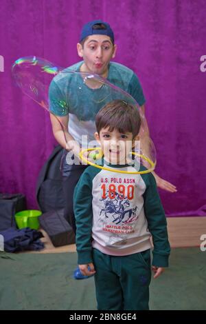 Seifenblasen zeigen. Kinderparty. Geburtstag der Kinder. Mit Seifenblase auf der Geburtstagsparty der Kinder spielen. Im Inneren der Seifenblase am Geburtstag Stockfoto