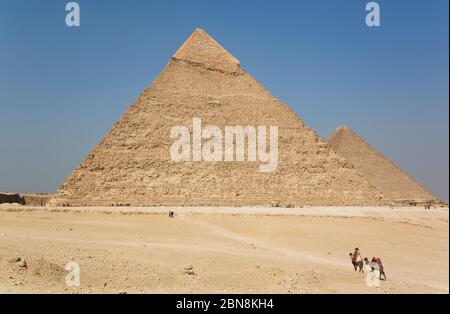 Lokaler Mann auf Kamel, Khafre Pyramide (Hintergrund), große Pyramiden von Gizeh, UNESCO-Weltkulturerbe, Gizeh, Ägypten Stockfoto