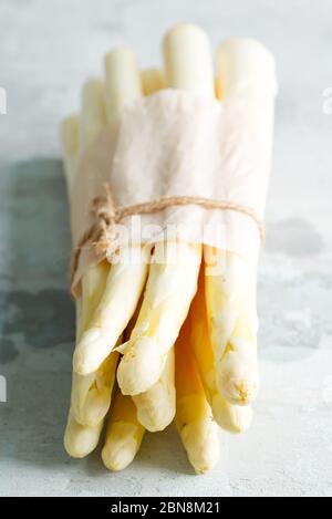 Bio-Lebensmittel. Gesundes Essen Kochkonzept. Roh frisch gepflückte rohe Bio-weiße Spargelstiele vor Steinhintergrund. Stockfoto