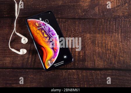 Galati, Rumänien - 29. Mai 2019: Apple stellt das neue Smartphone iPhone XS und iPhone XS Max vor. IPhone XS Max mit Kopfhörern auf Holztisch. Stockfoto