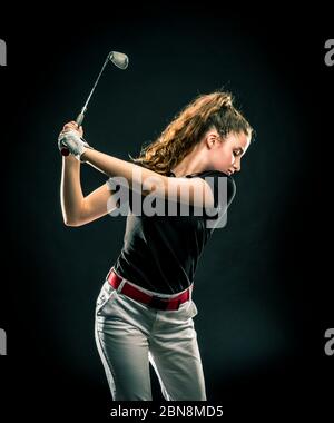 Mädchen auf der Suche nach dem perfekten Golf erschossen isoliert auf schwarzem Hintergrund Stockfoto