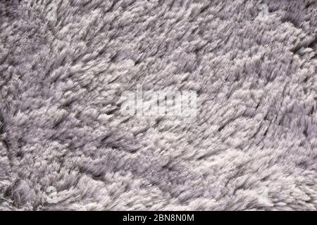 Künstliche Felltextur für Hintergrund Nahaufnahme. Flauschige graue Material Hintergrund. Kinder Spielzeug Kunstfell Textur. Nahaufnahme, Makro. Stockfoto
