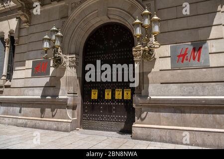 Barcelona, Spanien. Mai 2020. Kritische Plakate gegen das zerstörerische und extraktivistische kapitalistische System werden an der Tür des schwedischen Stores H&M (Hennes & Mauritz) von der Umweltgruppe Rebellion oder Extinction Barcelona während der Covid-19-Pandemie ausgestellt. Quelle: SOPA Images Limited/Alamy Live News Stockfoto