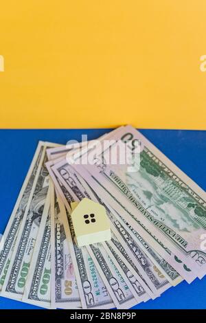 Eine kleine Kopie des Hauses steht auf einem Bündel von Dollars.Real Estate konzeptionell mit Haus und Dollar.Property Investment-Konzept. Planung Einsparungen Stockfoto