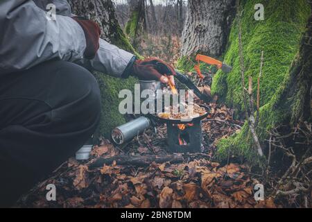 Kochen Sie auf einer Wandertour mit einem Rucksack. Stockfoto