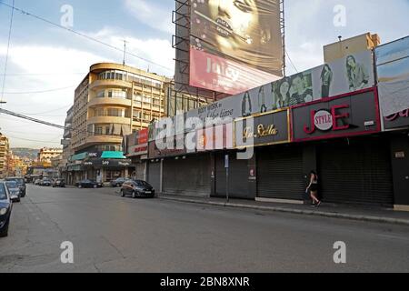 Beirut, Libanon. Mai 2020. Am 13. Mai 2020 geht eine Frau in Beirut, Libanon, an geschlossenen Geschäften vorbei. Die Zahl der COVID-19-Infektionen im Libanon stieg am Mittwoch um acht auf 878 Fälle an, während die Zahl der Todesopfer unverändert bei 26 blieb, berichtete die Nationale Nachrichtenagentur. Der Libanon schließt das ganze Land seit Mittwoch für die kommenden vier Tage ab, um die Ausbreitung des Virus zu begrenzen, nachdem in den letzten Tagen eine Zunahme der Infektionen beobachtet wurde. Kredit: Bilal Jawich/Xinhua/Alamy Live News Stockfoto