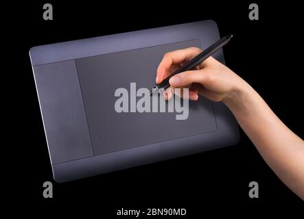 Hand hält digitalen Grafikstift und Zeichnung Grafik-Tablet isoliert auf schwarz Stockfoto