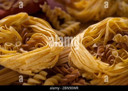 Verschiedene Arten von italienischen Pasta. Spaghetti, Tagliatelle, Fusilli, Pappardelle, Fettuccine. Verschiedene rohe Pasta Set aus einem ungesäuerten Teig o gemacht Stockfoto