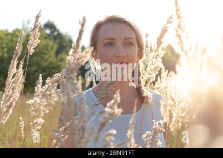 Porträt eines niedlichen Mädchen. Ziemlich blond mit blauen Augen. Die helle Morgensonne scheint auf das Mädchen. Stockfoto